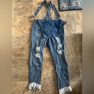 Overalls with rips and lace .
